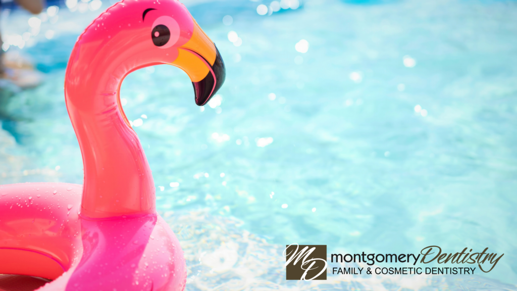 A bright pink inflatable flamingo float drifting in clear, sparkling blue swimming pool water with sunlit reflections. The Montgomery Dentistry Family and Cosmetic Dentistry logo is located in the bottom right corner.